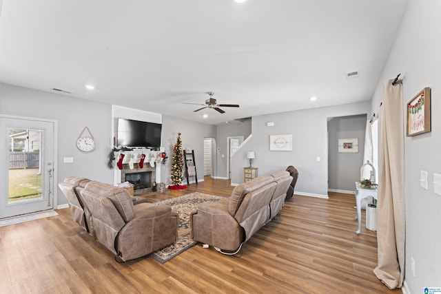 living room with light hardwood / wood-style flooring and ceiling fan