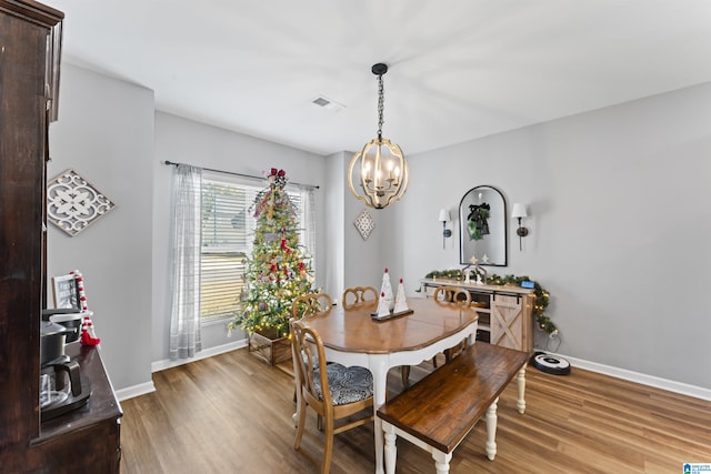 dining area with hardwood / wood-style flooring and a chandelier