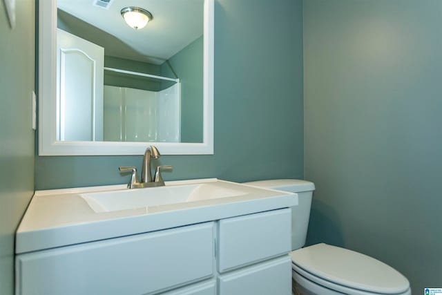 bathroom featuring vanity, toilet, and walk in shower