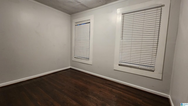 empty room featuring dark wood-type flooring and a textured ceiling