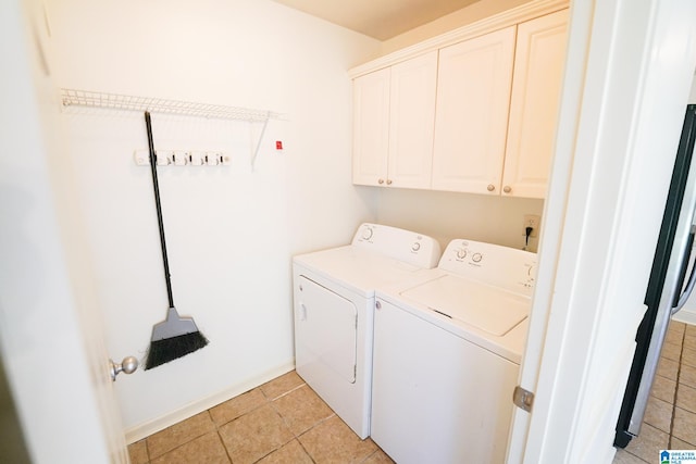 washroom with cabinets, washing machine and dryer, and light tile patterned flooring