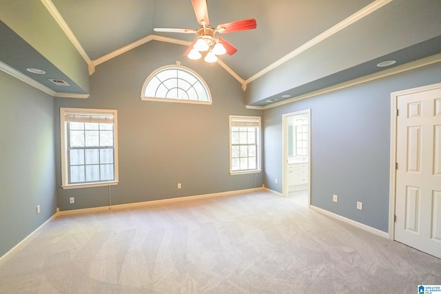 spare room featuring light colored carpet, crown molding, ceiling fan, and lofted ceiling