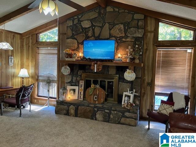 living room with ceiling fan, a fireplace, carpet floors, and lofted ceiling with beams