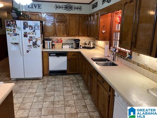 kitchen with decorative backsplash, sink, and white appliances