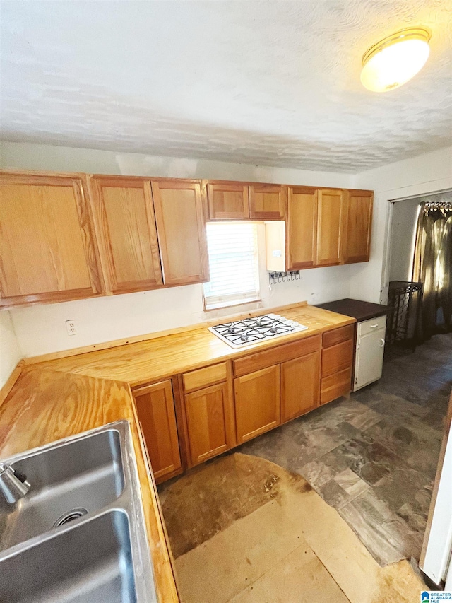 kitchen featuring white gas cooktop, sink, and wood counters