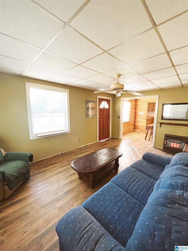 living room featuring a fireplace, ceiling fan, hardwood / wood-style floors, and a drop ceiling