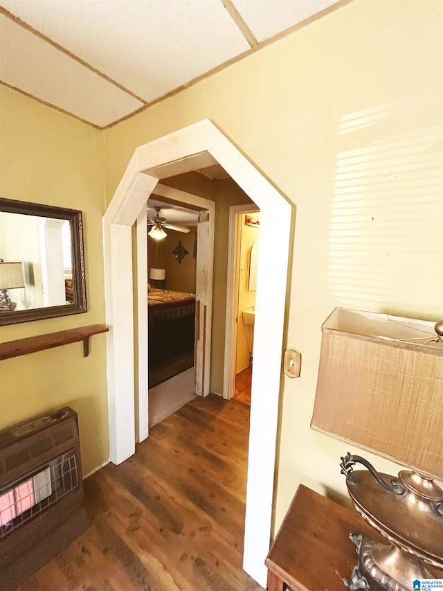 corridor with dark hardwood / wood-style flooring, sink, and heating unit