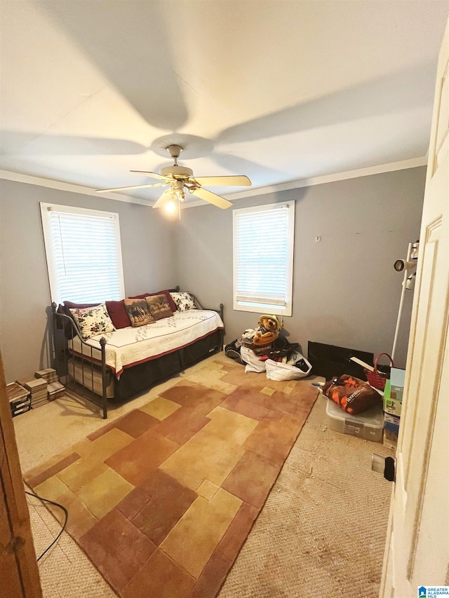 bedroom with carpet floors, ceiling fan, and crown molding