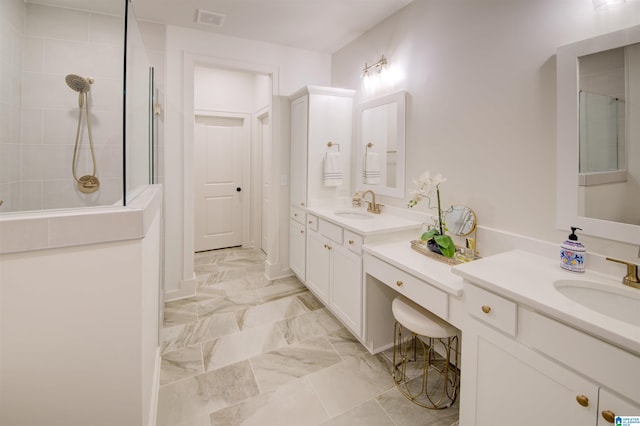 bathroom featuring a tile shower and vanity