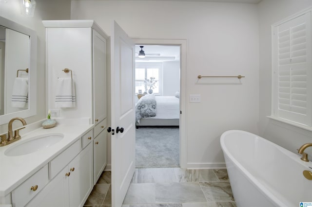 bathroom with ceiling fan, vanity, and a bath