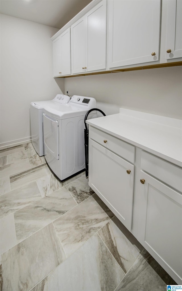 clothes washing area with cabinets and independent washer and dryer