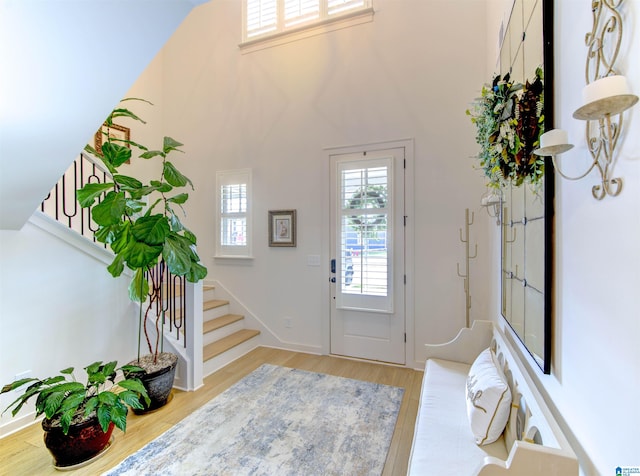 entryway featuring light hardwood / wood-style floors and a high ceiling