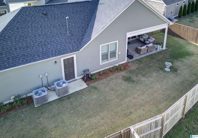 rear view of property with a lawn, a patio area, central AC unit, and an outdoor hangout area