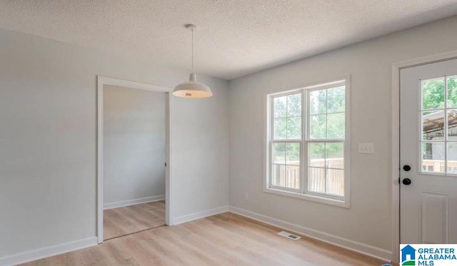 interior space with a textured ceiling and light wood-type flooring