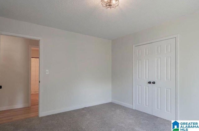 unfurnished bedroom featuring a closet, carpet floors, and a textured ceiling