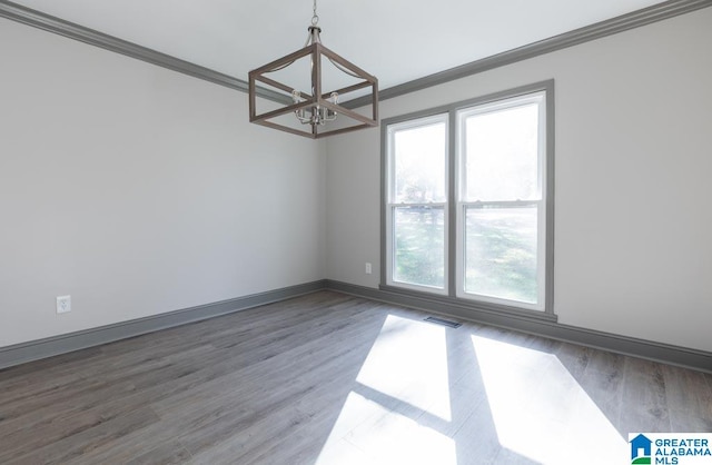 spare room with dark hardwood / wood-style floors, an inviting chandelier, and crown molding