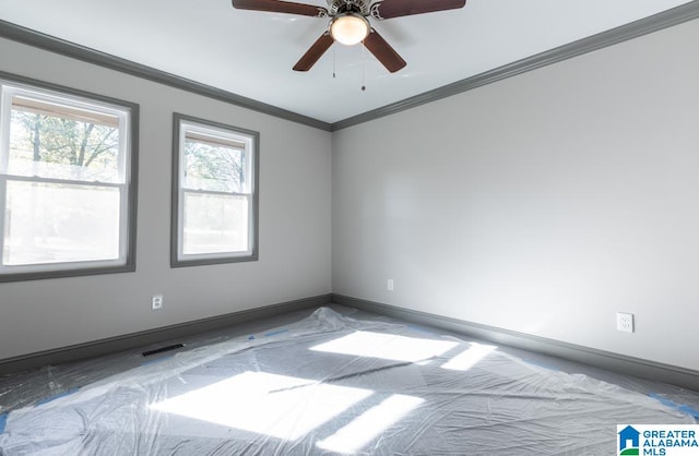 empty room featuring ceiling fan and crown molding