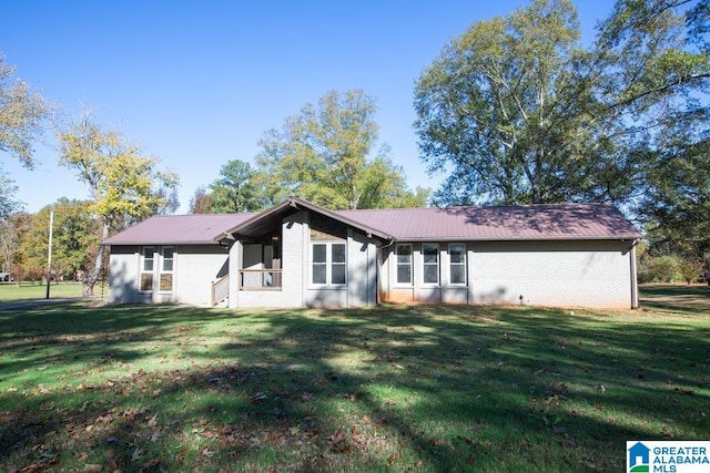 rear view of property with a yard