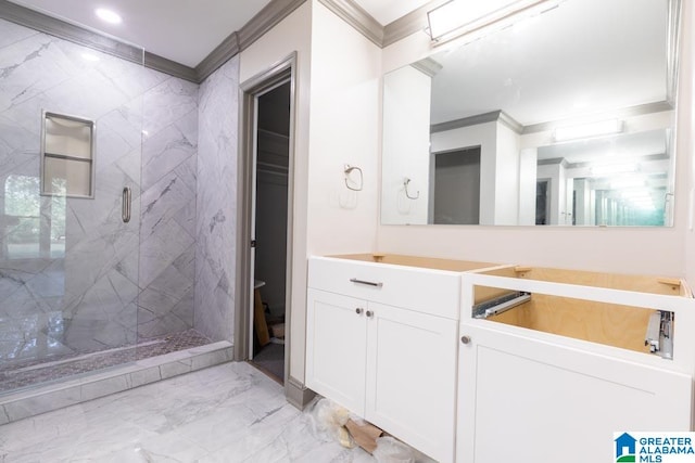 bathroom with a tile shower, vanity, and ornamental molding