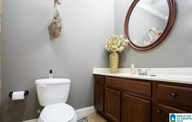 bathroom featuring vanity, ornamental molding, and toilet