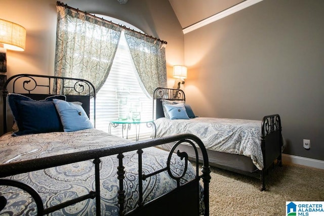 carpeted bedroom featuring vaulted ceiling and ornamental molding