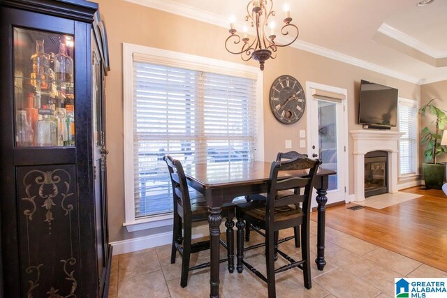 dining room with light wood-type flooring, plenty of natural light, and crown molding