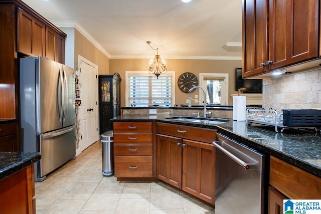 kitchen featuring sink, an inviting chandelier, dark stone countertops, appliances with stainless steel finishes, and ornamental molding