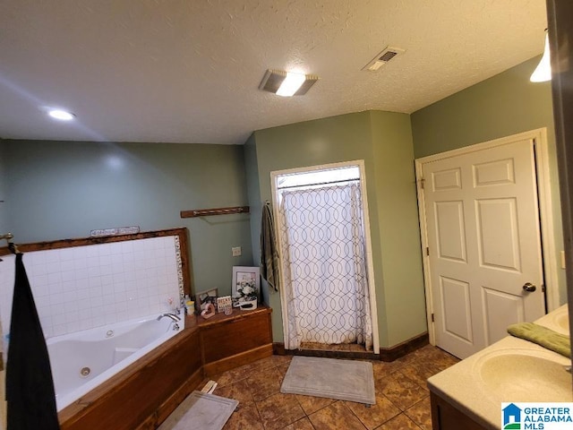 bathroom featuring a textured ceiling, vanity, tile patterned floors, and independent shower and bath