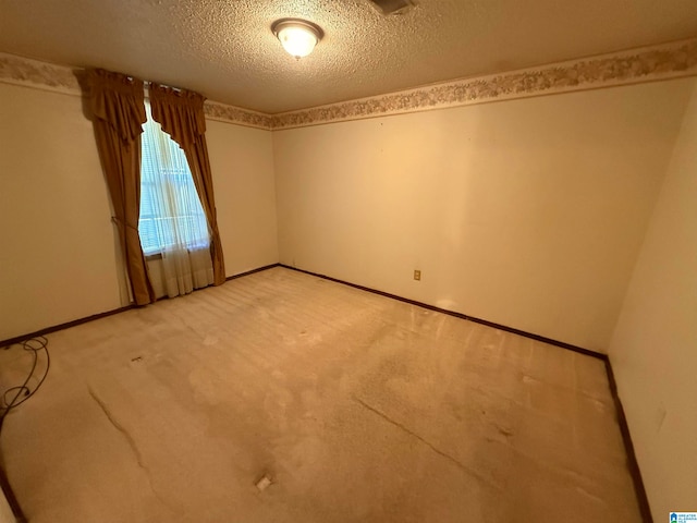 carpeted empty room featuring a textured ceiling