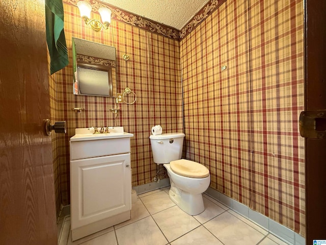 bathroom featuring tile patterned flooring, vanity, toilet, and a textured ceiling