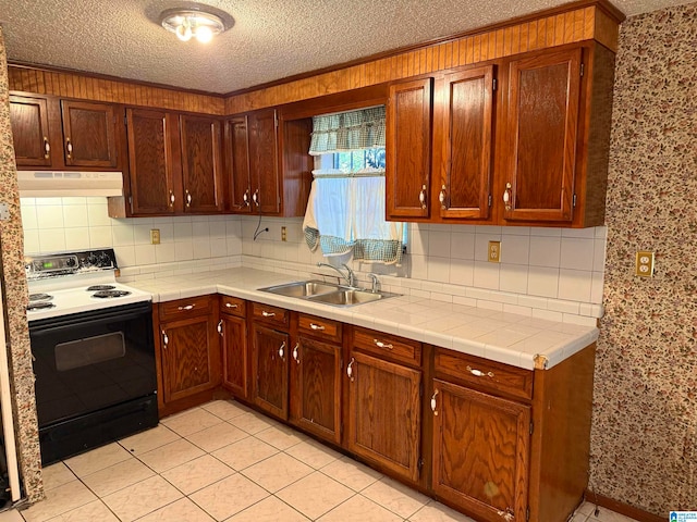 kitchen featuring white range with electric cooktop, light tile patterned flooring, sink, and a textured ceiling