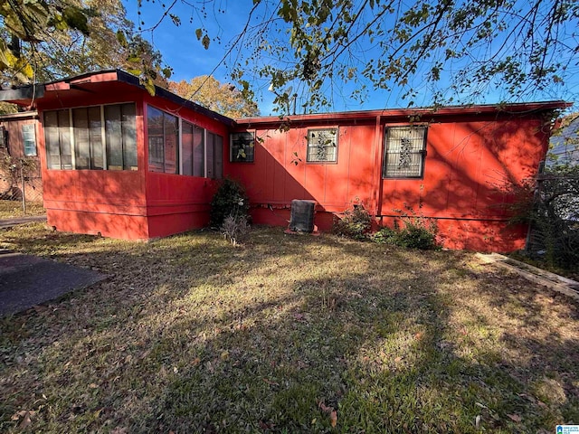 view of home's exterior featuring a sunroom and a yard