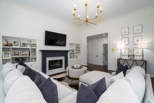 living room featuring ornamental molding, a fireplace, dark wood-type flooring, and a notable chandelier