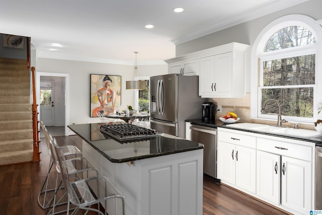 kitchen featuring pendant lighting, a breakfast bar, dark hardwood / wood-style floors, white cabinetry, and stainless steel appliances