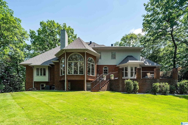 rear view of property featuring a yard and cooling unit