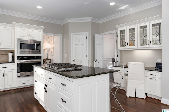 kitchen with stainless steel appliances, white cabinetry, and dark hardwood / wood-style floors