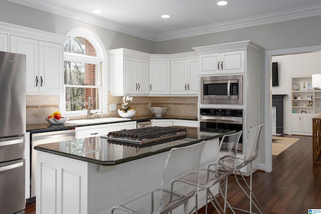 kitchen featuring a center island, decorative backsplash, dark hardwood / wood-style flooring, white cabinetry, and stainless steel appliances