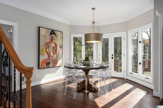 dining room featuring a healthy amount of sunlight, dark hardwood / wood-style flooring, ornamental molding, and french doors