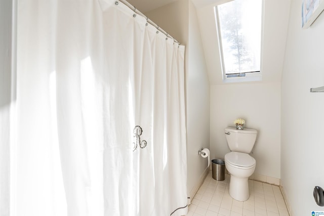 bathroom featuring tile patterned flooring, vaulted ceiling, and toilet