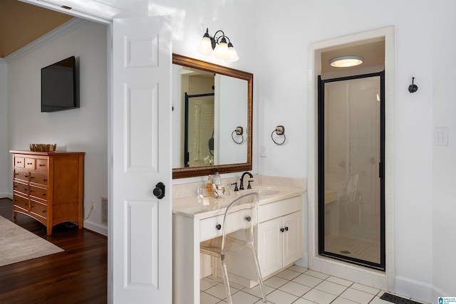 bathroom with vanity, hardwood / wood-style flooring, walk in shower, and ornamental molding