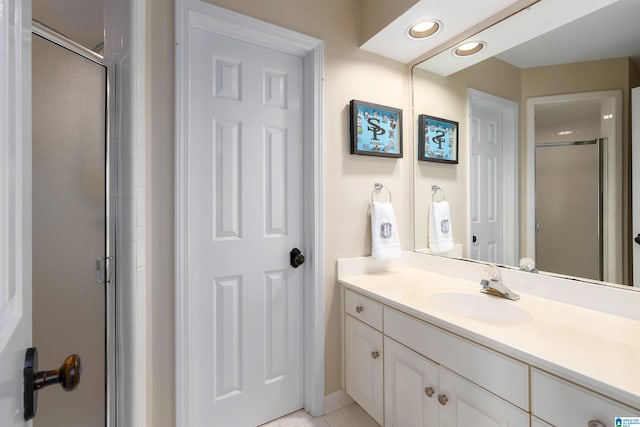 bathroom featuring tile patterned floors, vanity, and a shower with door