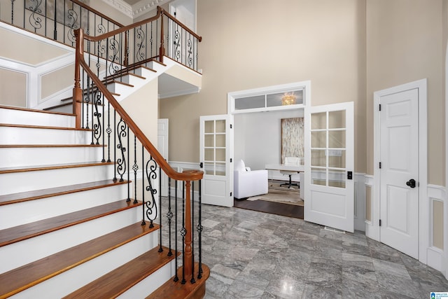 foyer featuring a towering ceiling and french doors