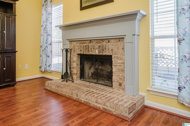 interior details with a brick fireplace and hardwood / wood-style flooring