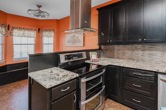 kitchen featuring backsplash, light stone countertops, stainless steel appliances, and wall chimney range hood