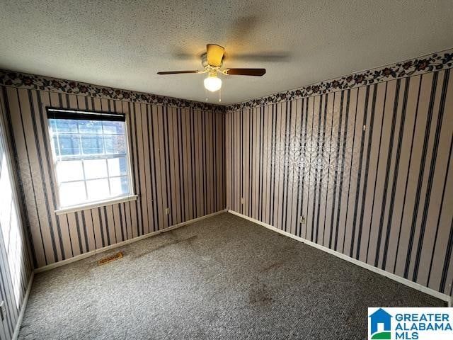 carpeted spare room with a textured ceiling and ceiling fan