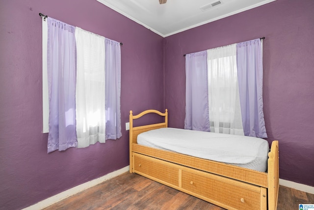 bedroom featuring ornamental molding, ceiling fan, and dark wood-type flooring