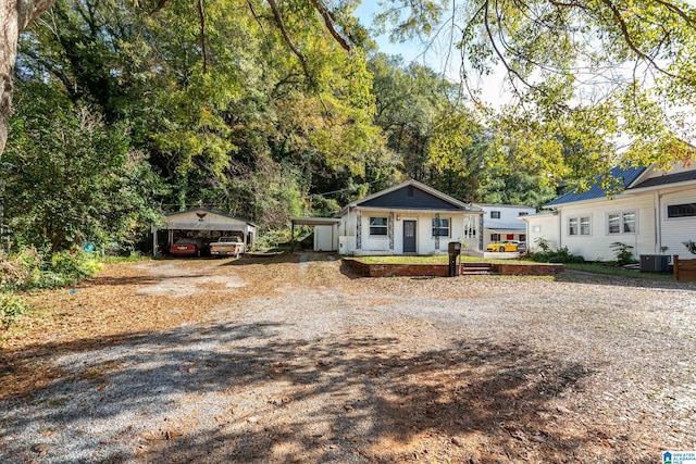 ranch-style home with cooling unit, covered porch, and a carport