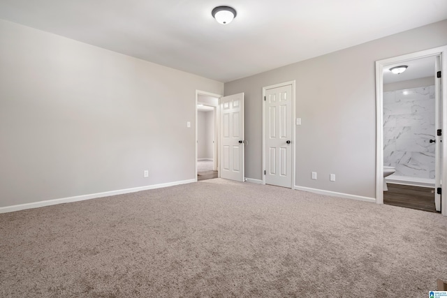 unfurnished bedroom featuring connected bathroom, carpet floors, and a closet