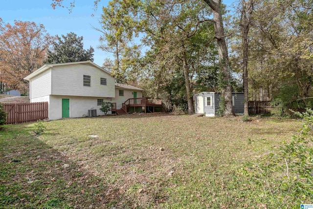 view of yard featuring a shed, a deck, and central air condition unit