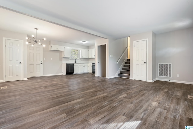 unfurnished living room with sink, dark wood-type flooring, and an inviting chandelier